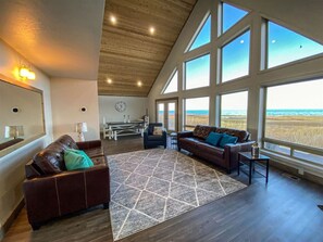 Cozy great room with panoramic lake views, vaulted ceilings, and leather seating for ultimate relaxation.