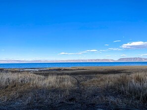 Tranquil lakeside serenity with endless blue skies and peaceful mountain views—nature at its finest.