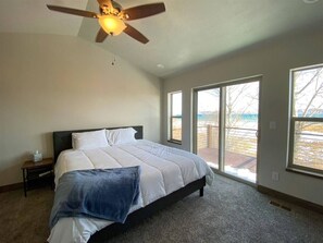 Welcoming bedroom retreat with serene lake views and private deck access for peaceful mornings.