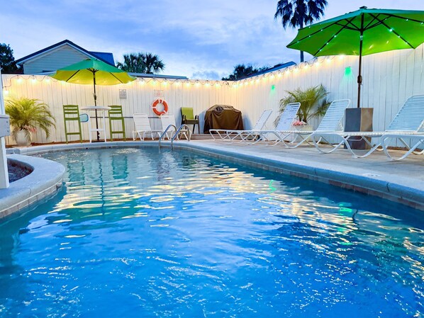Lighting, plants, and decor make the nighttime pool area into an oasis