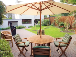 Private garden with teak tables and chairs, teak bench, parasol + 4 burner BBQ