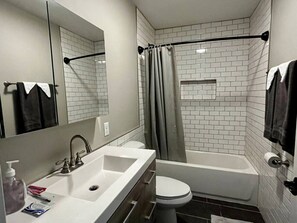 Bathroom with a soaking bathtub. Subway tile lined bath.