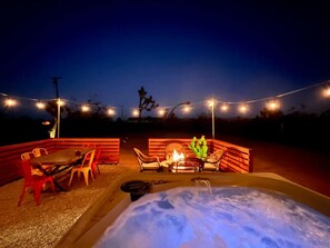 A hot tub, FirePit, BBQ grill and outdoor dining set, all next to each other for your evening entertainment. All are in the shade behind the house in the evening.