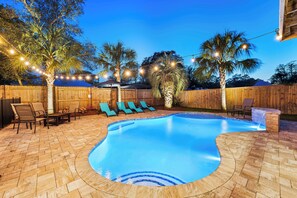 "Nautical Dreams" featuring a beautiful fenced in waterfall feature pool, lounge chairs and sun shade umbrellas.