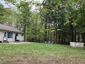 Huge, flat backyard lined with trees and nature.