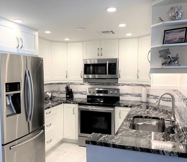 Bright kitchen with stainless steel appliances and granite countertops