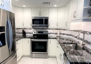 Bright kitchen with stainless steel appliances and granite countertops