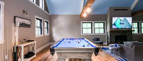 Play pool in the large open living room that overlooks mountain peak views.