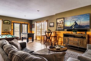 Game room with large TV and numerous games such as pool and foosball