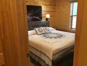 King-sized bed located on the lower (ground floor) level of the cabin.