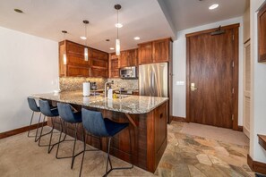 Breakfast bar and kitchen that has open sight lines through the main living area.