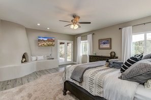 Grand Master Bedroom with a King Bed, Smart TV, a decorative fireplace (not operational), and Patio Access