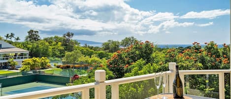 View of the tennis courts, lush landscape and the ocean from the lanai.