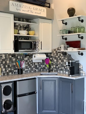 The kitchen features quartz counter, infrared stovetop, frig/freezer, and Kurig.