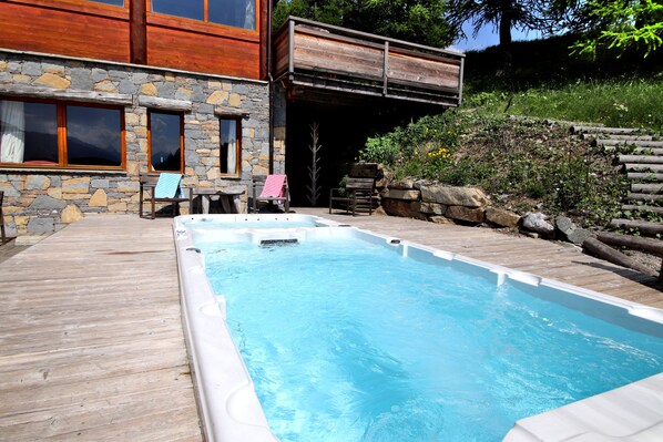 Le spa de nage avec un jacuzzi chauffé à 37° et piscine à 30° face à la montagne