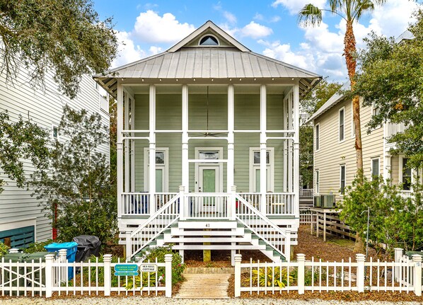 Coast Cottages East Beach Vacation Home - Classic low-country architecture in the Coast Cottages community—this elevated East Beach home features a welcoming front porch and charming white picket fence.
