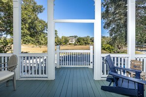 Coast Cottages Marsh View Front Porch - Relax on the Coast Cottages front porch with peaceful views of the marsh and salty breezes from East Beach—just steps from private beach access and island trails.