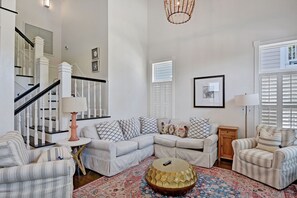 Coast Cottages St. Simons Island Living Room - Airy coastal living room with high ceilings, natural light, and comfortable seating—perfect for relaxing after a day at East Beach or the heated oceanfront pool.