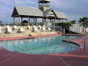 Coast Cottages Heated Oceanfront Pool – Pavilion View - Oceanfront pool at Coast Cottages with shaded pavilion, lounge chairs, and direct beach access—heated during spring break and holiday weeks or available year-round with advance notice.