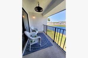 Balcony with fan overlooking pond and third hole of golf course, access from living room and main bedroom