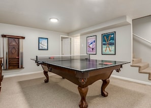 Billiards table and ping pong topper in basement rec room