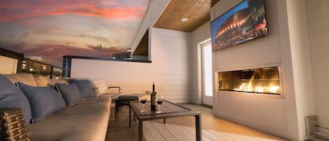 Rooftop patio with outdoor fireplace, smart TV, and lounge area. Includes incredible views of downtown.