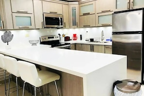 Remodeled kitchen. Ideally selected furniture and appliances, soft bar stools.