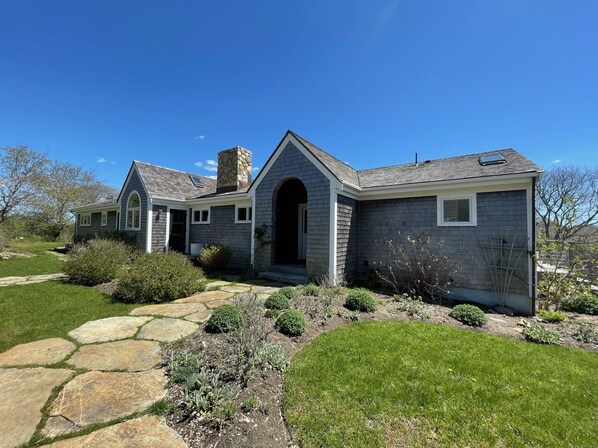 View of the front entry way and front of the house. Large stone walkway