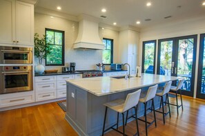 The kitchen features top of the line appliances, white backsplash tile and mesmerizing views of the marsh.