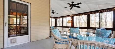 dining table with cushioned furniture on screened-in porch