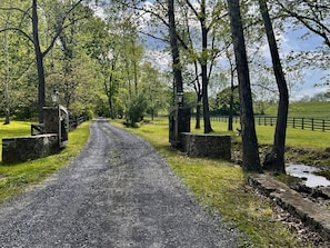 Farm entrance thru wooden gates along a stream.  The farm is 130 acres