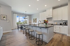 Large open kitchen with island bar seating for 4