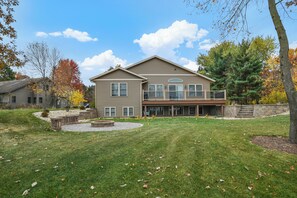 Rear of home view from the lake. Fire pit and large grass space for yard games.