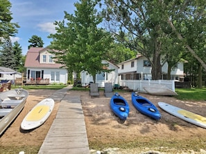 Beach area and kayaks, paddled boards, canoe, aluminum fishing boat 