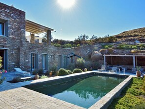 The villa, pool area, garden and shaded dining area with a BBQ