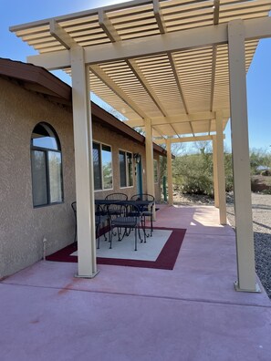 Pergola with table and chairs in front