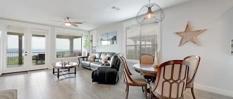 Living/Dining view toward balcony through picture frame window and french doors