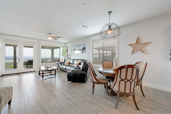 Living/Dining view toward balcony through picture frame window and french doors