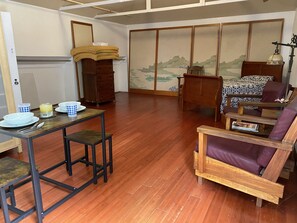 Living room with dining table and single bed in the back.