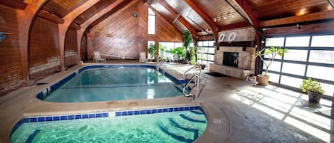 Indoor Pool & Spa with glass garage doors opening to the outdoor pool