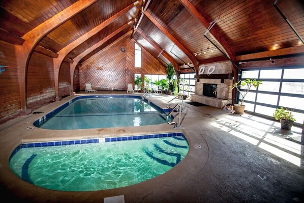 Indoor Pool & Spa with glass garage doors opening to the outdoor pool