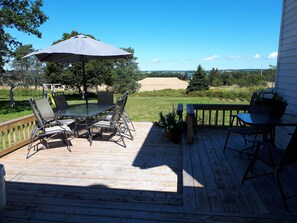 Back deck overlooking the fields and the West River. BBQ and swing set.