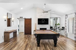  pool table room adorned with a warming fireplace and comfortable seating