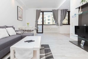 A grey sofa bed with a coffee table beside it.