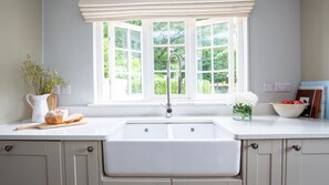 A kitchen with a view at Thatch Cottage