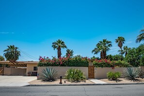 front of house featuring huge driveway and ample carport.