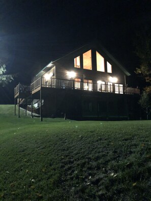 Night view looking up at cabin from lake.