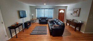 Inviting living room with fireplace and comfy leather couch and chair.