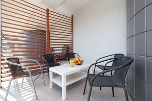 An outdoor balcony setup with a small table and chairs, perfect for relaxation.