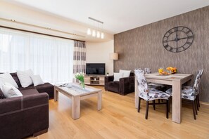 A view of a living room and adjacent dining area with a stylish table and chairs.
